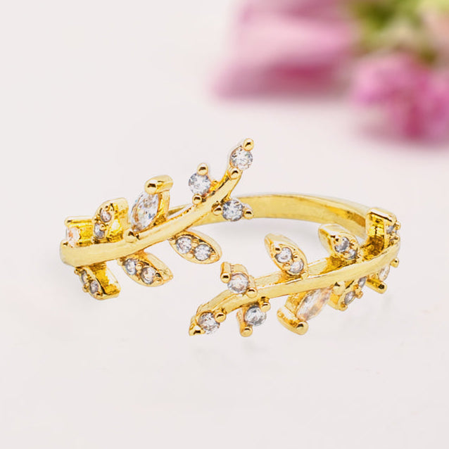 Gold ring with leaf design on a light background