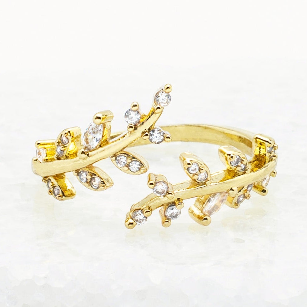 Gold ring with diamond accents on a light background